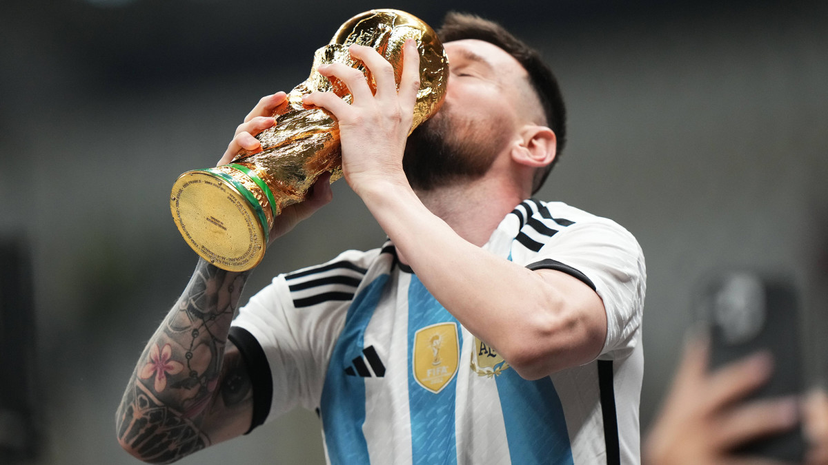 Lionel Messi kisses the World Cup trophy