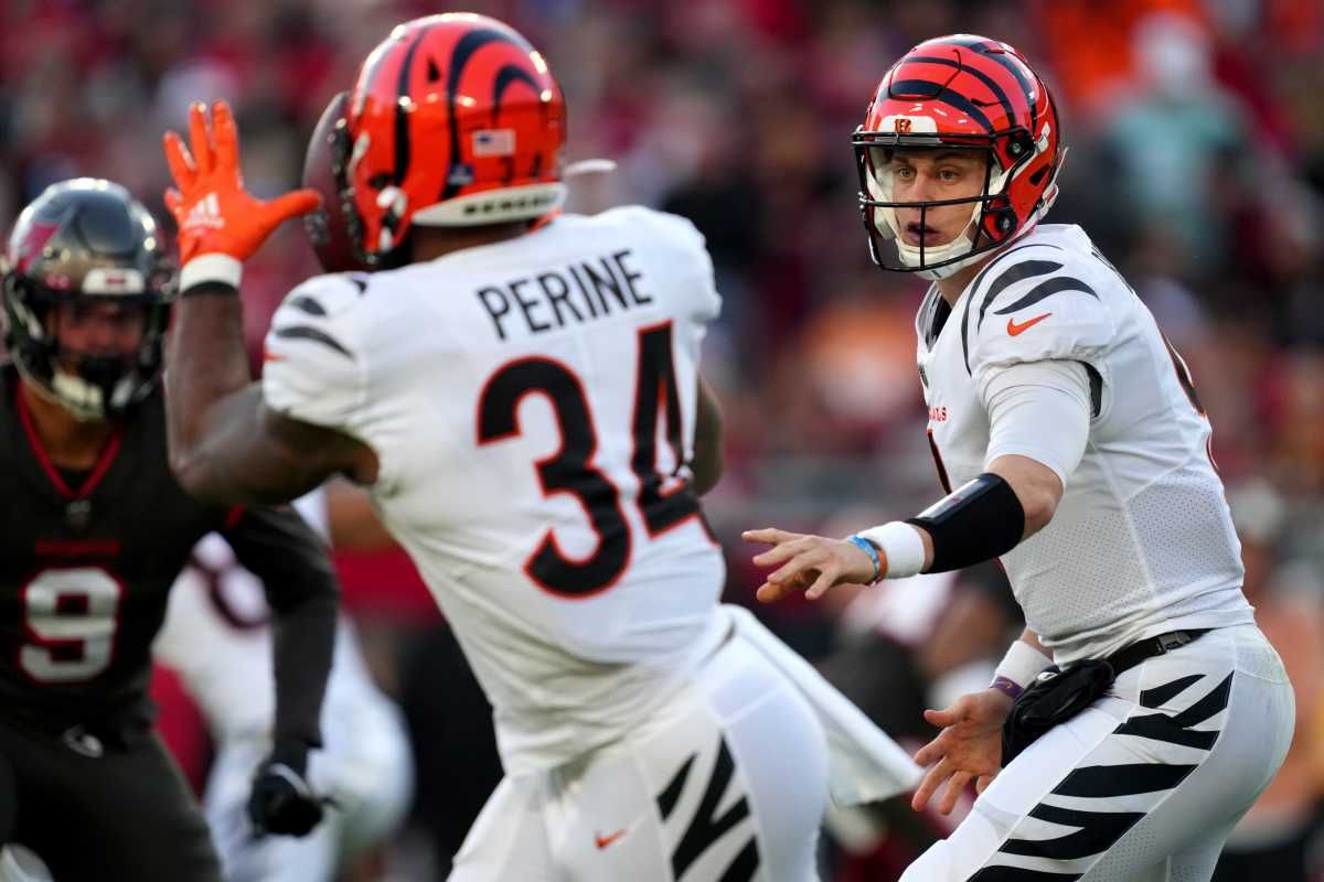 Cincinnati Bengals quarterback Joe Burrow (9) flips the ball to Cincinnati Bengals running back Samaje Perine (34) in the first quarter during a Week 15 NFL game against the Tampa Bay Buccaneers, Sunday, Dec. 18, 2022, at Raymond James Stadium in Tampa, Fla. Nfl Cincinnati Bengals At Tampa Bay Buccaneers Dec 18 1997