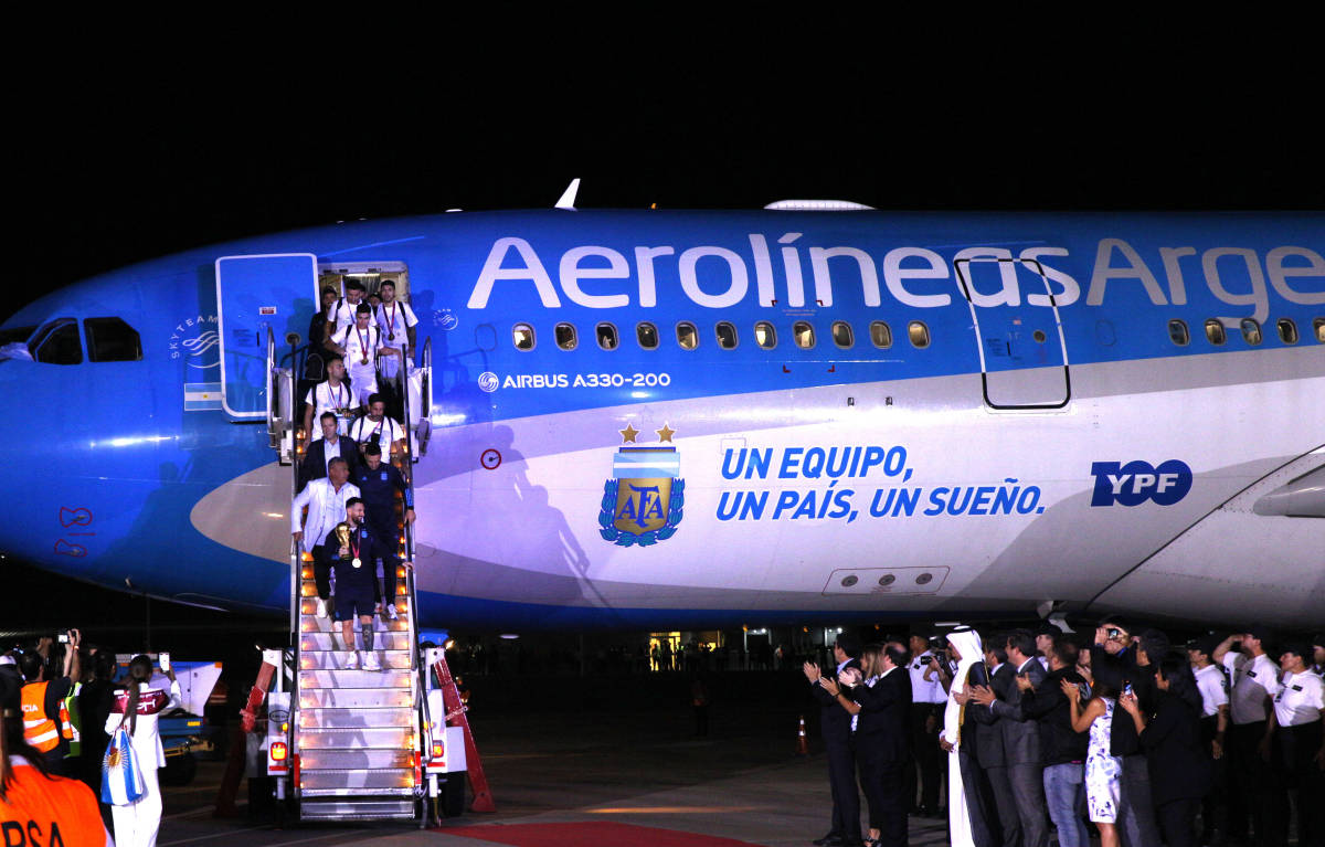 Lionel Messi pictured carrying the World Cup trophy off an airplane in Buenos Aires less than 48 hours after he and his Argentina teammates beat France in the final of Qatar 2022