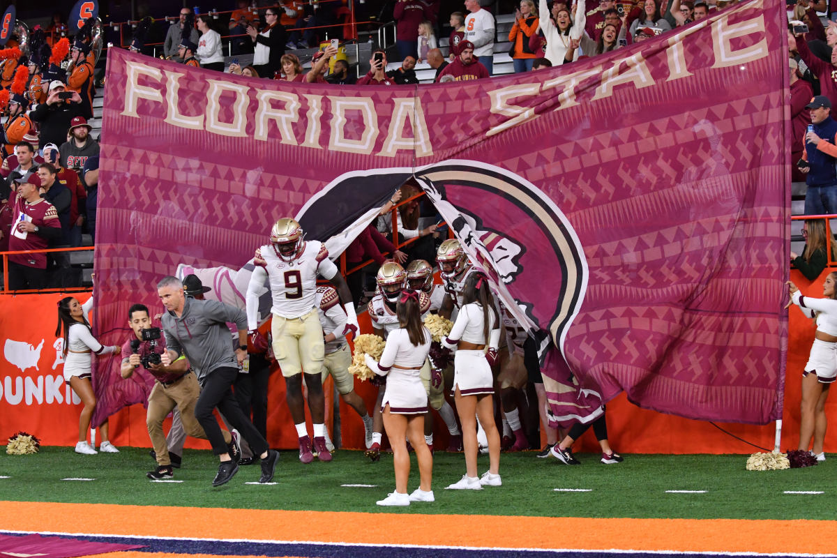 Syracuse, New York, USA; Florida State Seminoles head coach Mike Norvell (left) and defensive end Derrick McLendon II (9) lead their team onto the field before a game against the Syracuse Orange at JMA Wireless Dome.