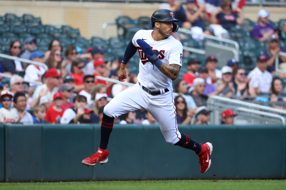 shortstop Carlos Correa runs in a Twins uniform while looking behind him with his head turned