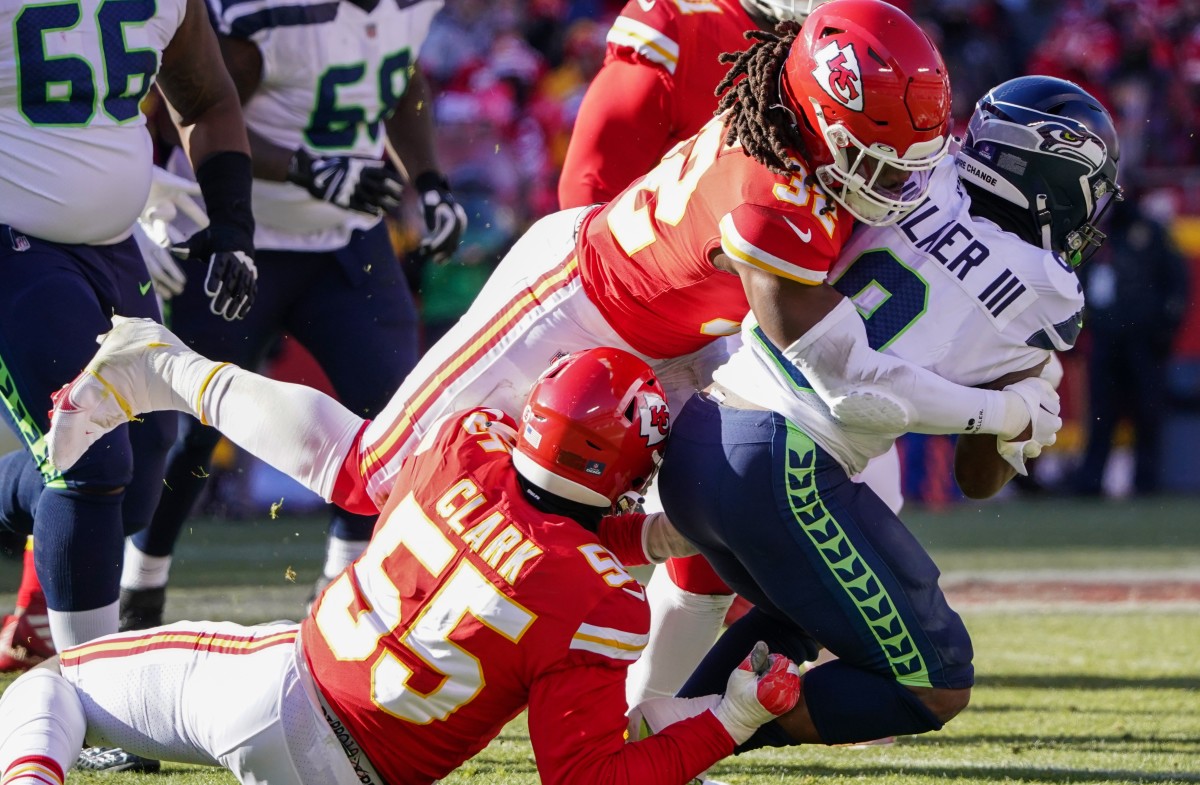 Seattle Seahawks running back Kenneth Walker III (9) is tackled by Kansas City Chiefs defensive end Frank Clark (55) and linebacker Nick Bolton (32) during the first half at GEHA Field at Arrowhead Stadium.