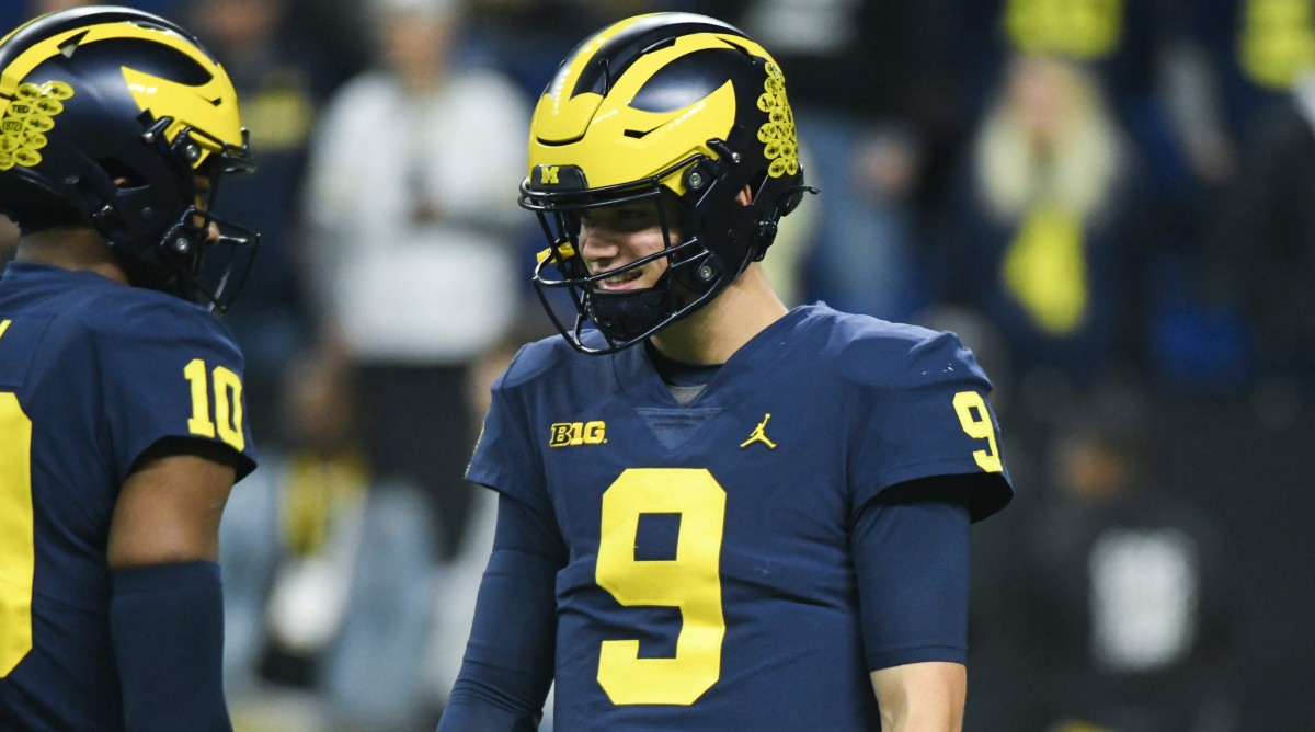 Michigan quarterback J.J. McCarthy (9) and Michigan quarterback quarterback Alex Orji (10) talk before the Big Ten Championship against Purdue.