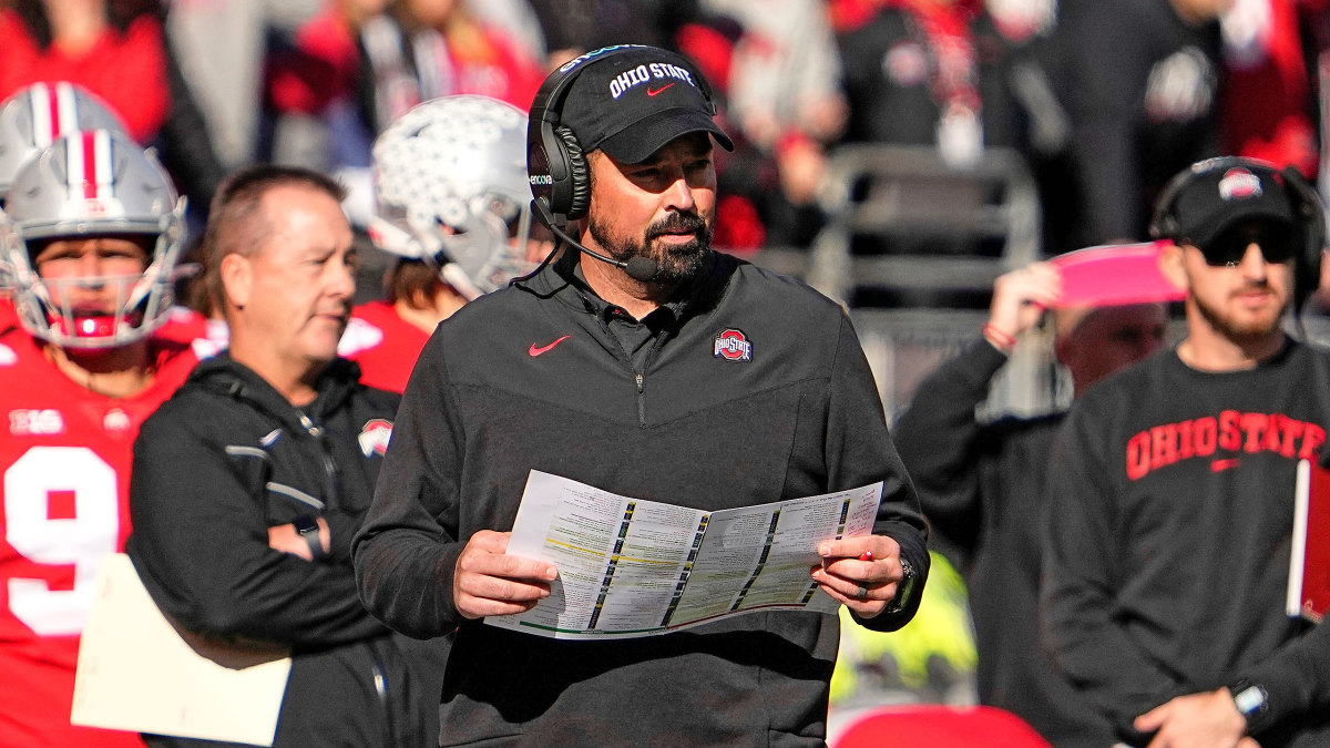 Ohio State coach Ryan Day holds a sheet of paper on the sideline