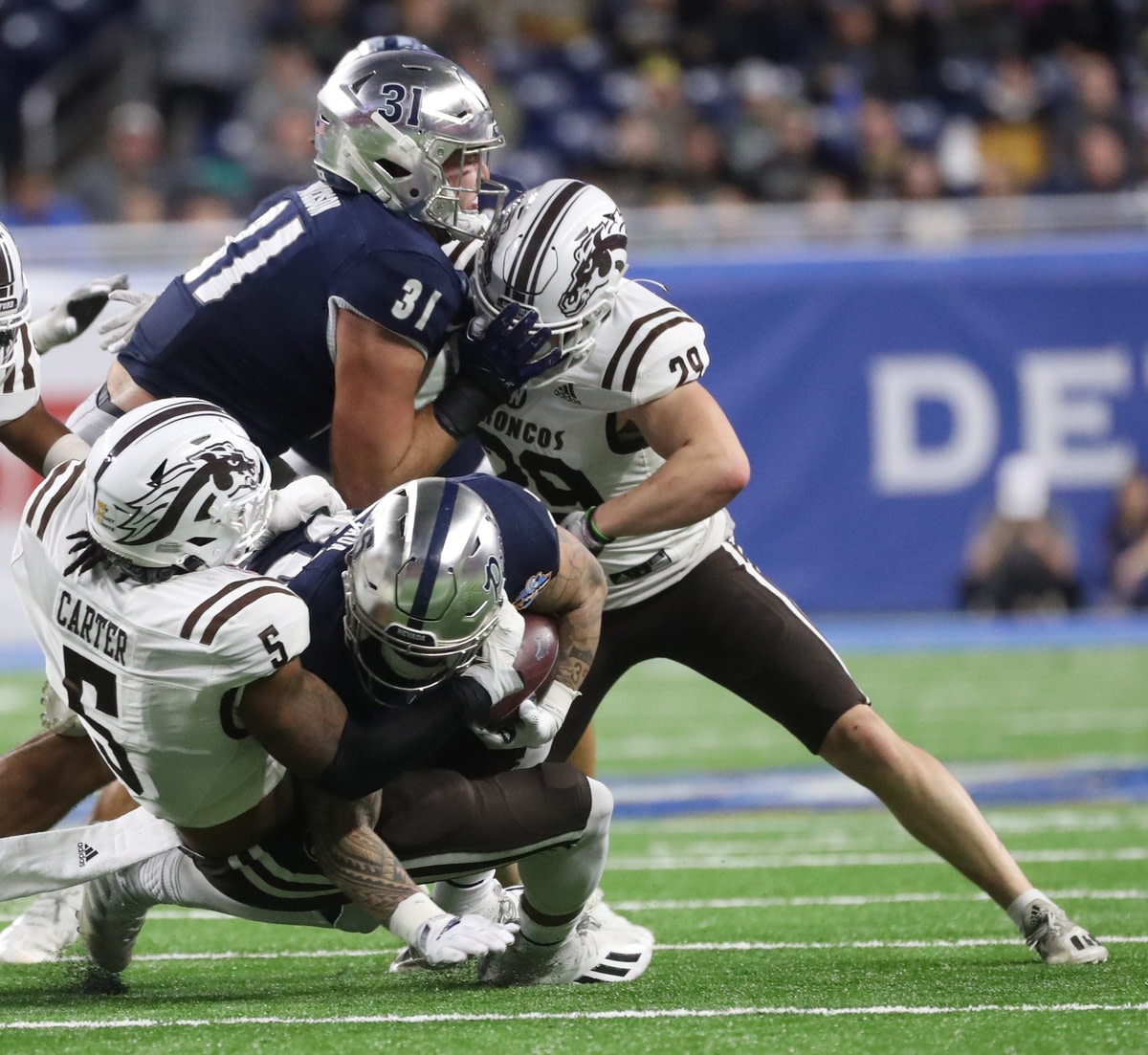 Western Michigan defensive lineman Andre Carter (5) tackles Nevada running back Toa Taua (35) during first half action of the Quick Lane Bowl on Monday, Dec. 27, 2021, at Ford Field.