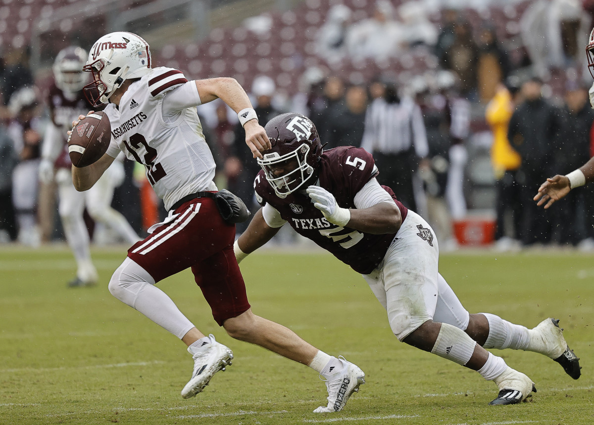 COLLEGE STATION, TEXAS - NOVEMBER 19: Brady Olson #12 of the Massachusetts Minutemen scrambles top avoid being tackled by Shemar Turner #5 of the Texas A&M Aggies during the fourth quarter at Kyle Field on November 19, 2022 in College Station, Texas. (Photo by Bob Levey/Getty Images)