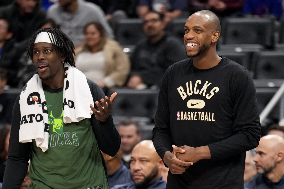 Milwaukee Bucks forward Khris Middleton (22) smiles from the bench with guard Jrue Holiday (21)