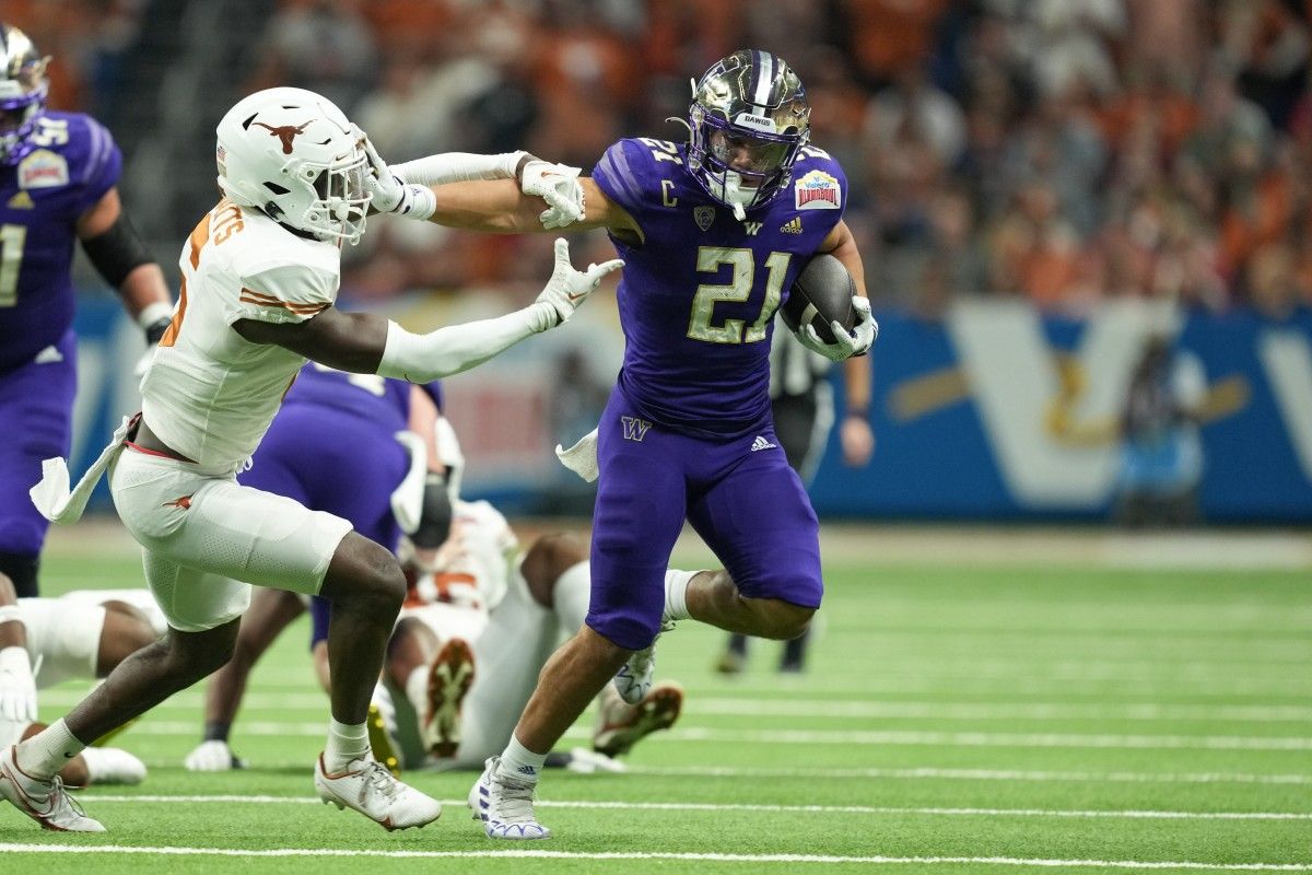 Vince Taulapapa scores on a 42-yard touchdown run, stiff-arming Texas cornerback Ryan Watts.