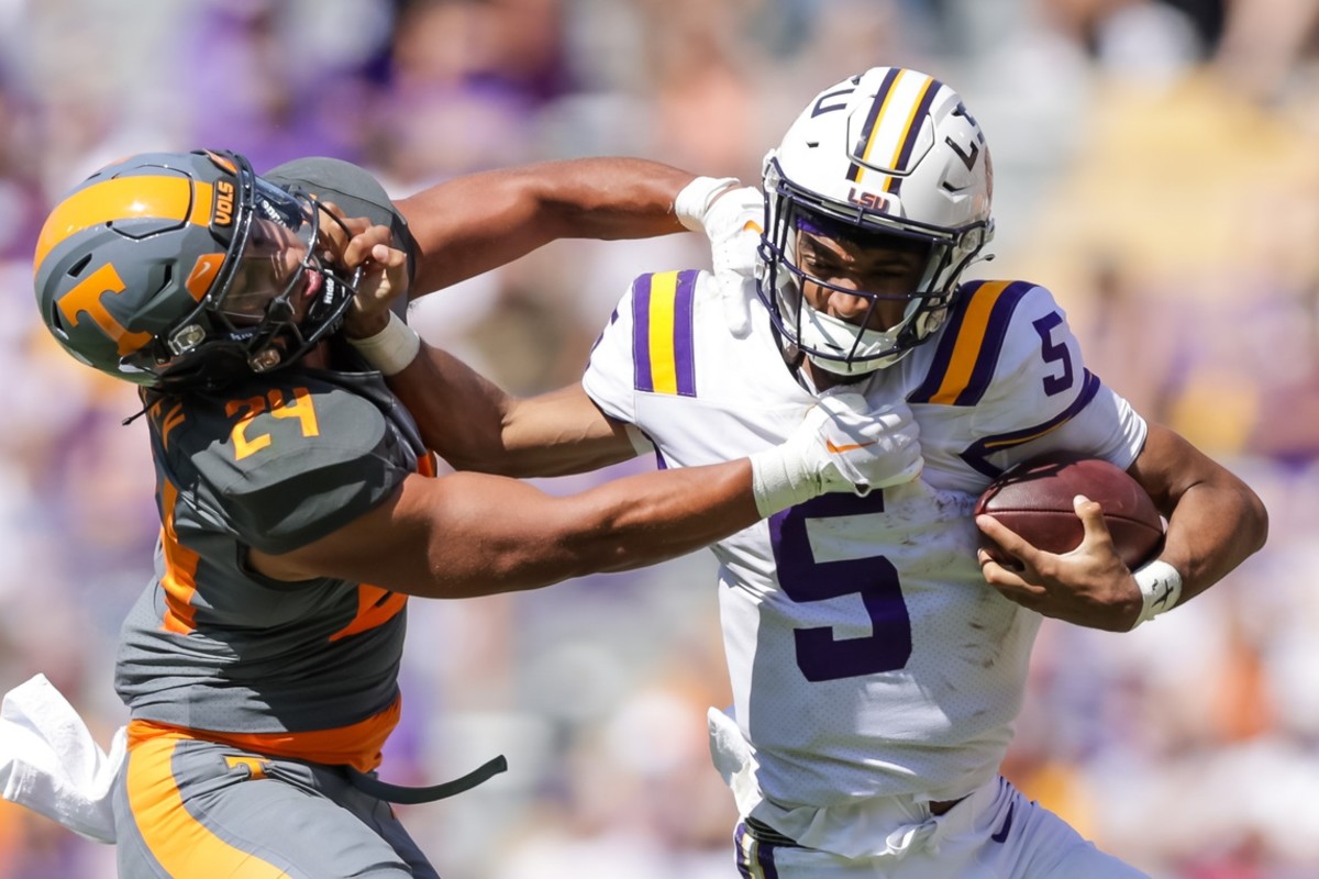 Oct 8, 2022; Baton Rouge, Louisiana, USA; LSU Tigers quarterback Jayden Daniels (5) stiff arms Tennessee Volunteers linebacker Aaron Beasley (24) as he tries to tackle him during the second half at Tiger Stadium.
