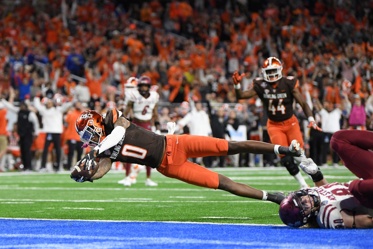 Detroit, Michigan, USA; Bowling Green State University wide receiver Tyrone Broden (0) catches a pass and dives into the end zone for a touchdown as New Mexico State University linebacker Trevor Brohard (80) can't make the tackle in the fourth quarter of the 2022 Quick Lane Bowl at Ford Field.