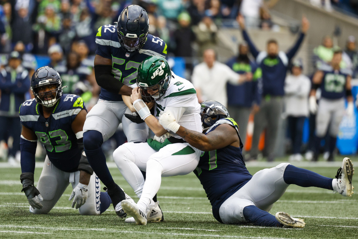 Seattle Seahawks defensive end Darrell Taylor (52) and defensive tackle Quinton Jefferson (77) sack New York Jets quarterback Mike White (5) during the second quarter at Lumen Field.