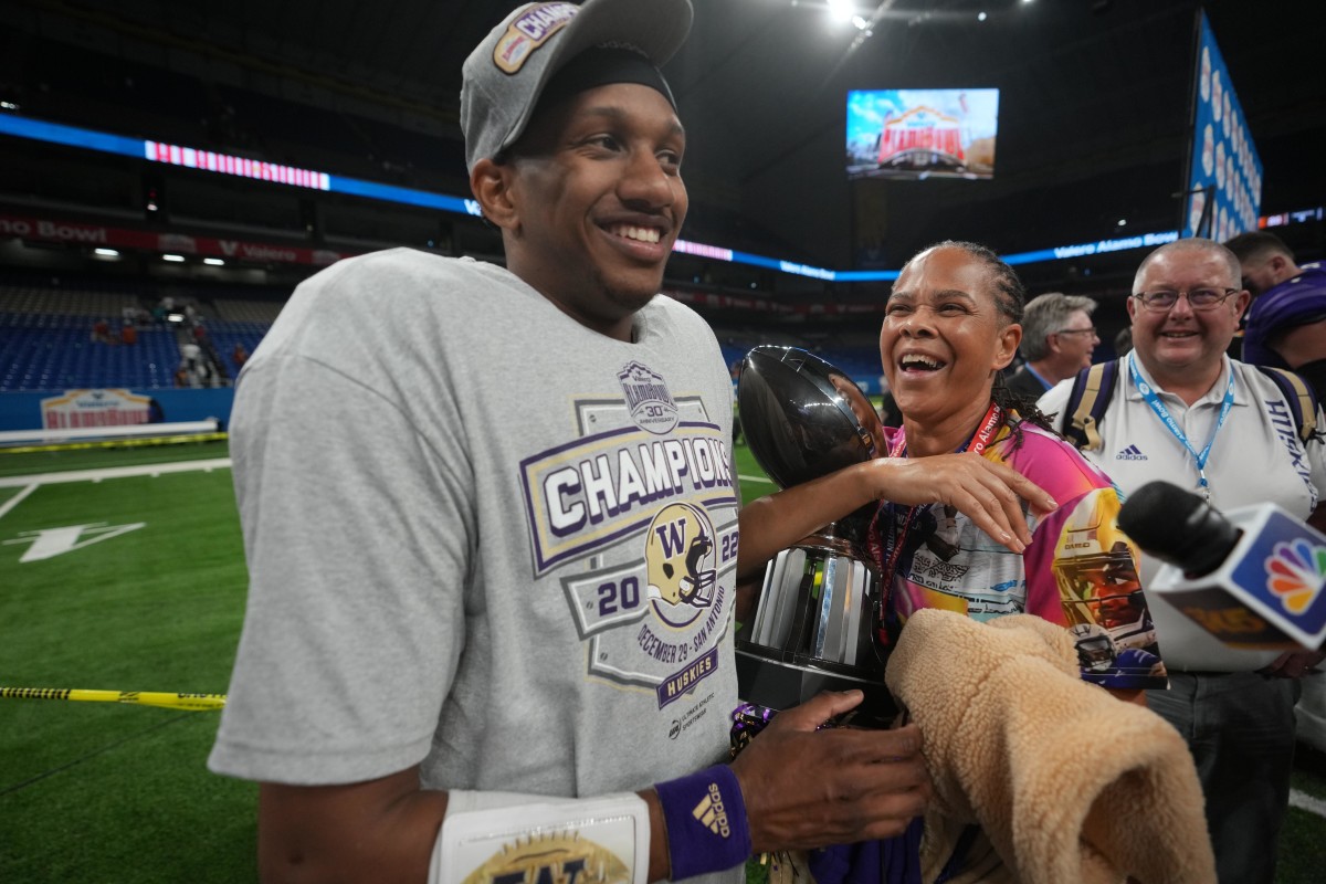 San Antonio, Texas, USA; Washington Huskies quarterback Michael Penix Jr. (9) holds the most valuable offensive player trophy after the 2022 Alamo Bowl against the Texas Longhorns at Alamodome.