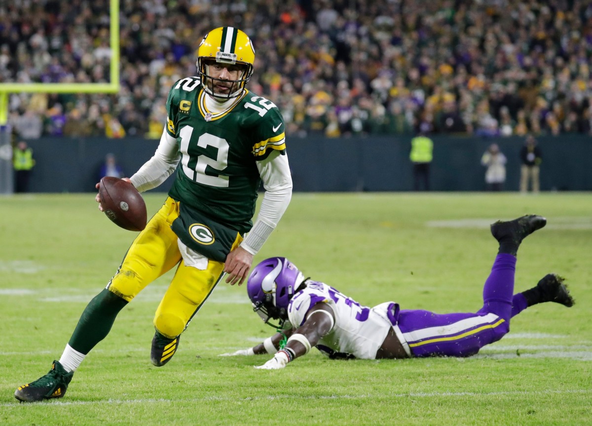 Packers quarterback Aaron Rodgers escapes a Vikings defender during their Week 17 matchup in Green Bay.