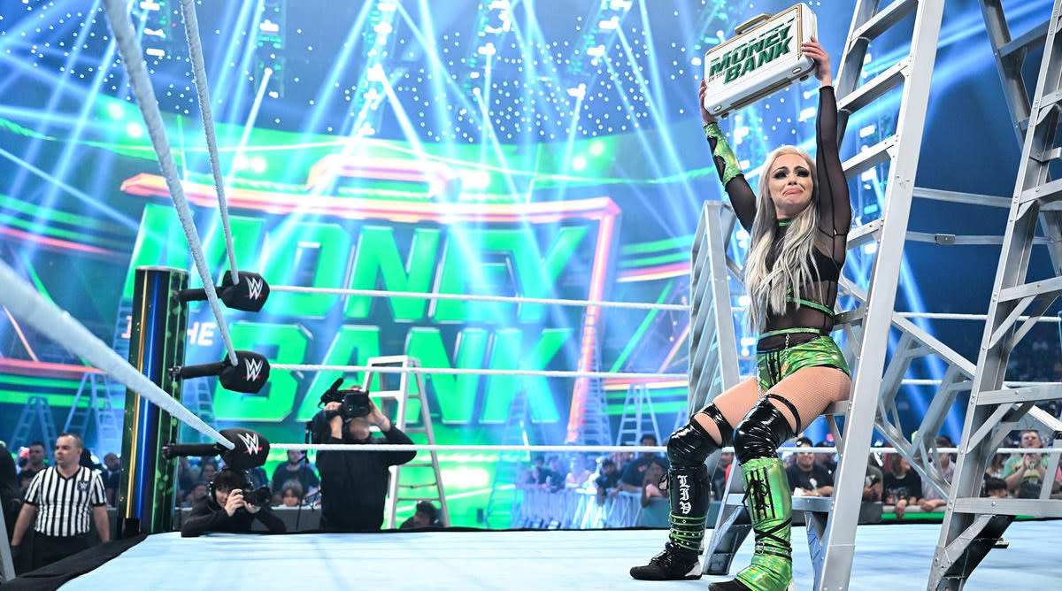 Wrestler Liv Morgan holds up the WWE’s Money in the Bank suitcase after winning the 2022 event
