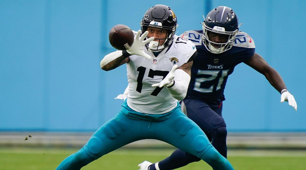 Dec 11, 2022; Nashville, Tennessee, USA; Jacksonville Jaguars tight end Evan Engram (17) pulls in a first down catch while defended by Tennessee Titans cornerback Roger McCreary (21) during the second quarter at Nissan Stadium.