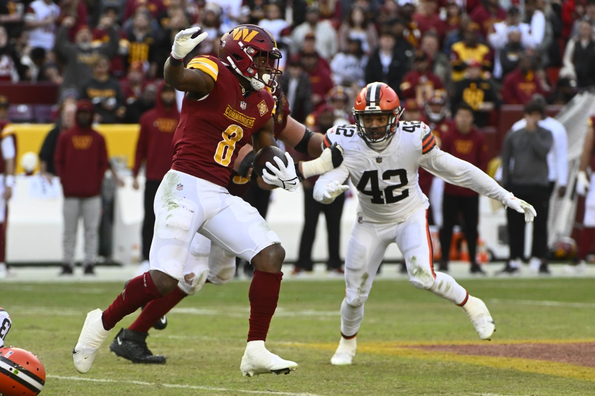 Jan 1, 2023; Landover, Maryland, USA; Washington Commanders running back Brian Robinson Jr. (8) carries the ball as Cleveland Browns linebacker Tony Fields II (42) defends during the second half at FedExField.