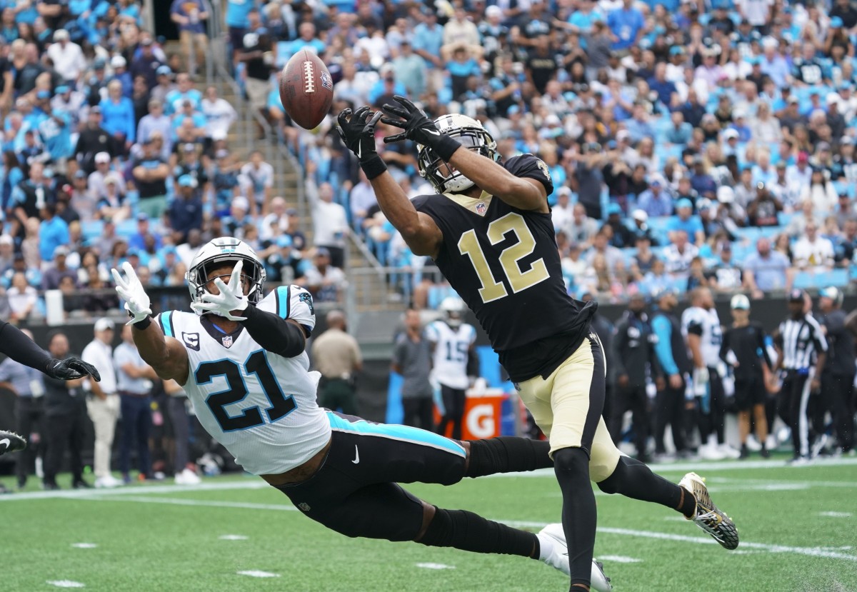 Sep 25, 2022; New Orleans Saints receiver Chris Olave (12) and Carolina Panthers safety Jeremy Chinn (21) go after the ball. Mandatory Credit: James Guillory-USA TODAY Sports