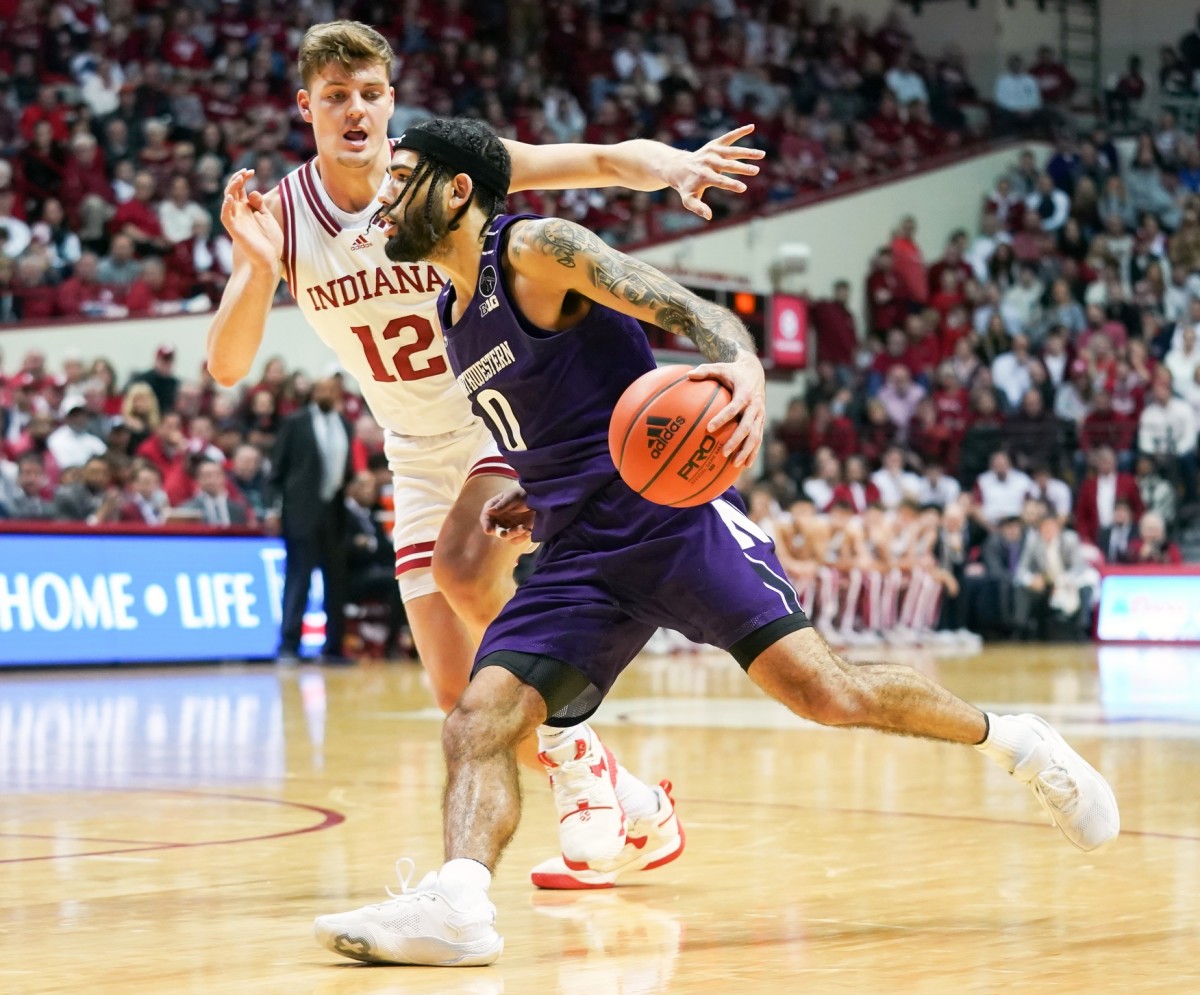 Northwestern Wildcats guard Boo Buie (0) attempts a drive to the basket versus Indiana Hoosiers forward Miller Kopp (12) during the second half at Simon Skjodt Assembly Hall.
