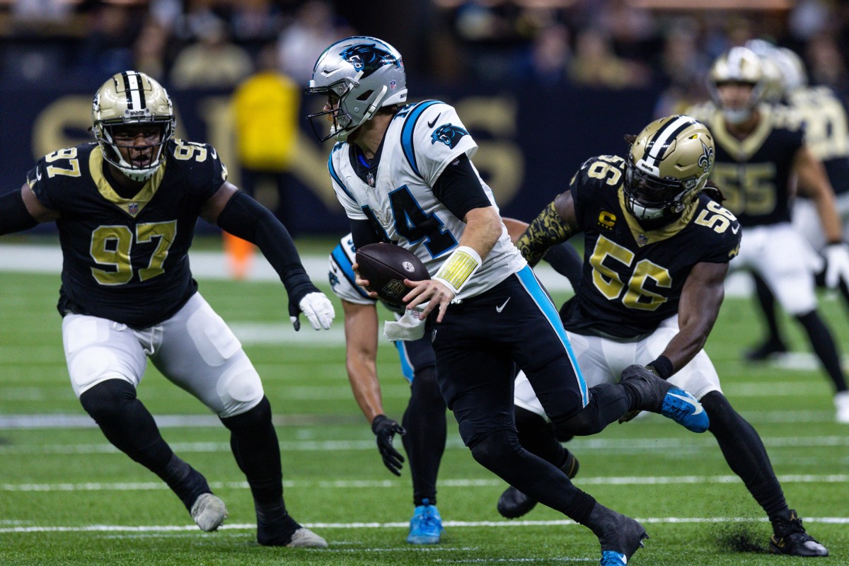 Carolina Panthers quarterback Sam Darnold (14) scrambles out the pocket against New Orleans Saints defensive end Malcolm Roach (97) and linebacker Demario Davis (56). Mandatory Credit: Stephen Lew-USA TODAY Sports