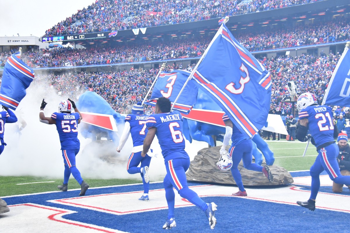 The Bills run onto the field with flags with the No. 3 to honor their teammate, Damar Hamlin, during Week 18.