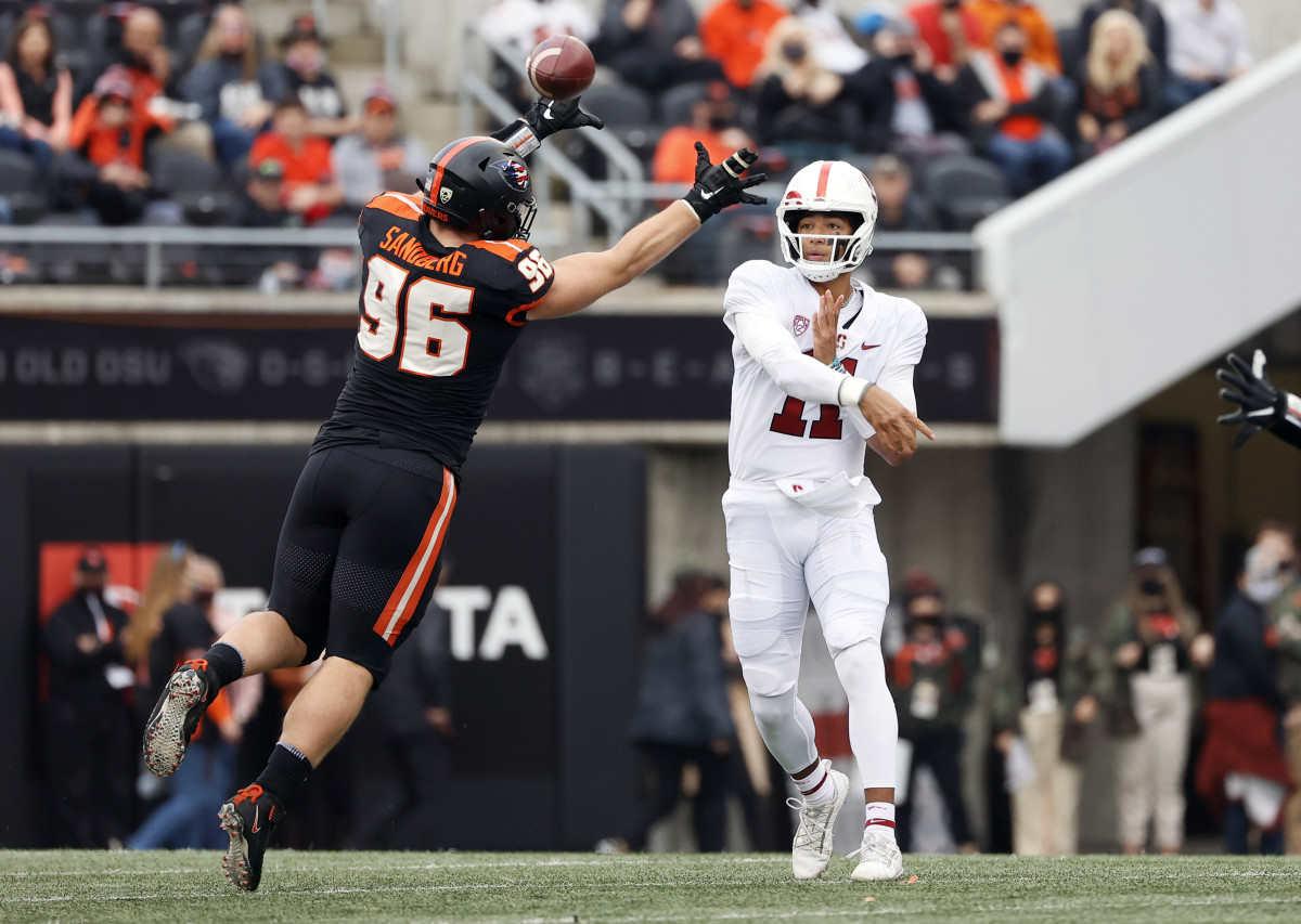 Oregon, USA; Stanford Cardinal quarterback Ari Patu (11) throws under pressure from Oregon State Beavers defensive lineman Simon Sandberg (96) during the first half at Reser Stadium