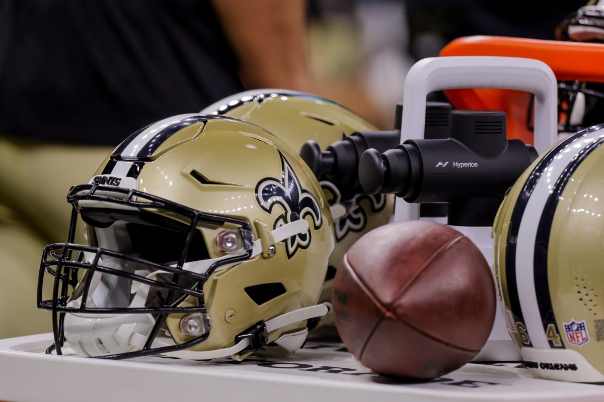 New Orleans Saints helmet and football on the sidelines of a preseason matchup with the Los Angeles Chargers.