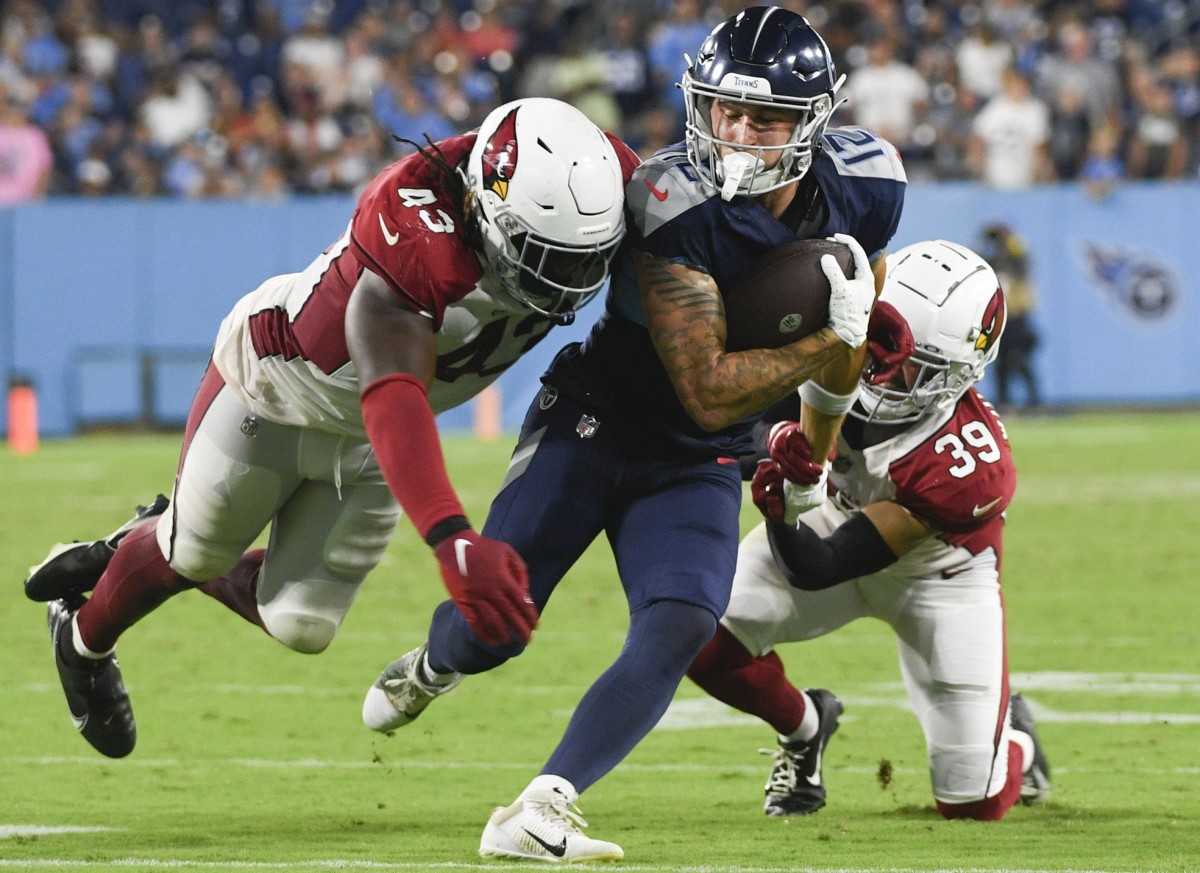 Tennessee Titans wide receiver Mason Kinsey (12) runs the ball against Arizona Cardinals linebacker Jesse Luketa (43) and cornerback Jace Whittaker (39) after a catch during the fourth quarter of a preseason game at Nissan Stadium.