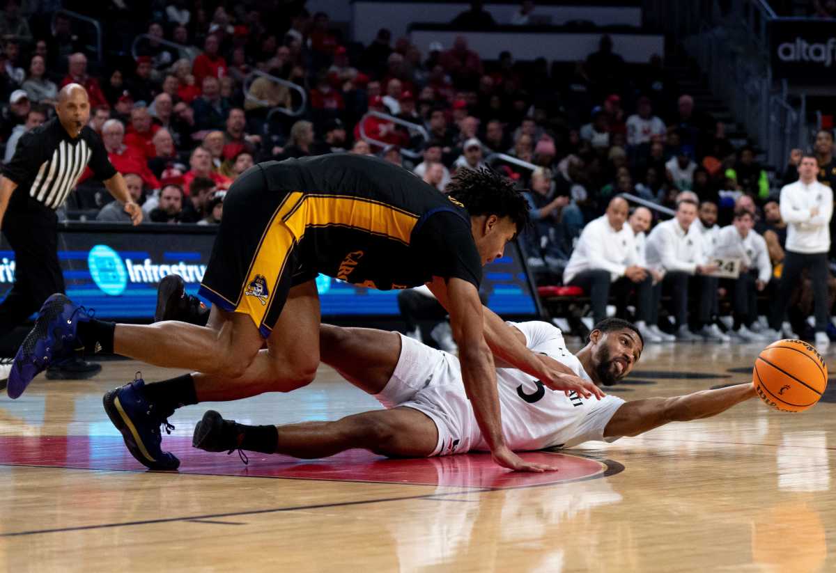 Cincinnati Bearcats guard David DeJulius (5) passes the ball from the ground as East Carolina Pirates guard Quentin Diboundje (4) defends in the second half of the NCAA men s basketball game at Fifth Third Arena in Cincinnati on Wednesday, Jan. 11, 2023. Ncaa Basketball Eastern Carolina Pirates At Cincinnati Bearcats