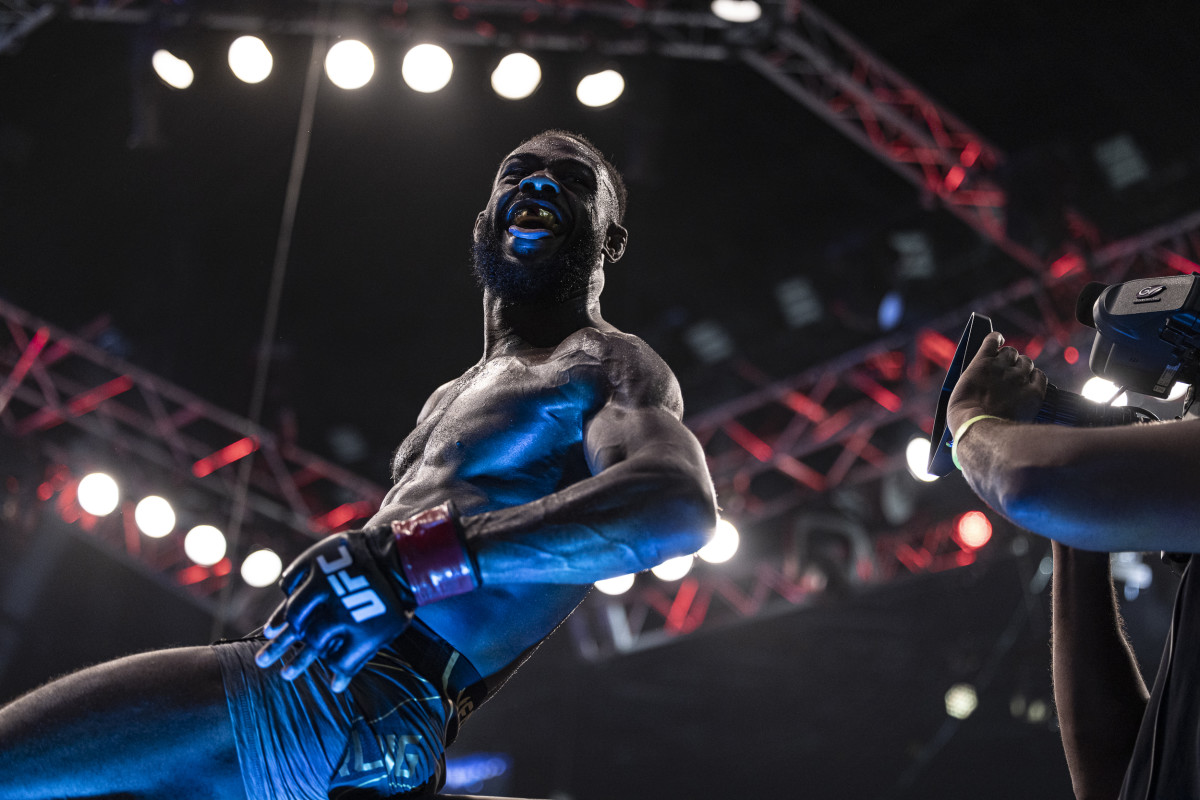 Aljamain Sterling (red gloves) celebrates after defeating T.J. Dillashaw (blue gloves) during UFC 280 at Etihad Arena.