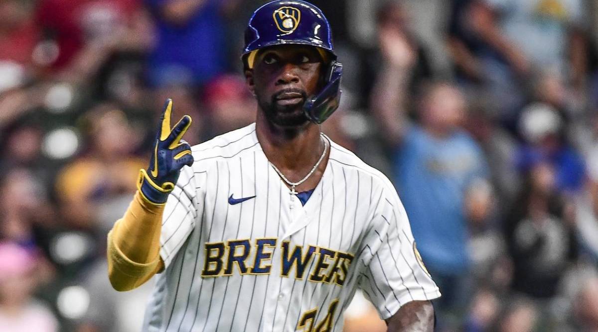 Andrew McCutchen holds up two fingers while running to first base in a game with the Brewers.