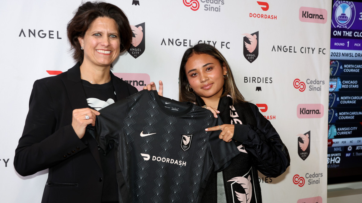Alyssa Thompson holds an Angel City FC uniform with co-founder Julie Uhrman after she was selected with the first overall pick in the 2023 NWSL Draft.