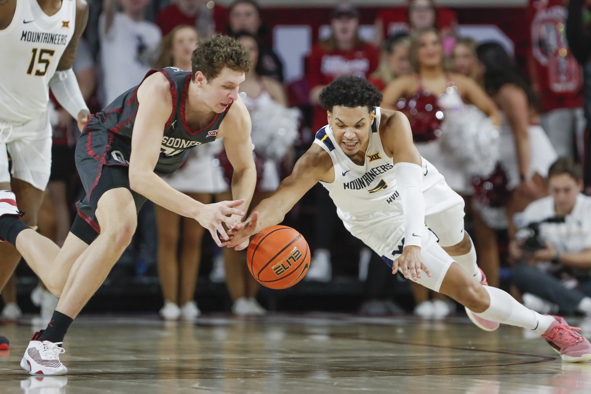 Jan 14, 2023; Norman, Oklahoma, USA; Oklahoma Sooners forward Jacob Groves (34) and West Virginia Mountaineers forward Tre Mitchell (3) reach for a loose ball during the second half at Lloyd Noble Center.