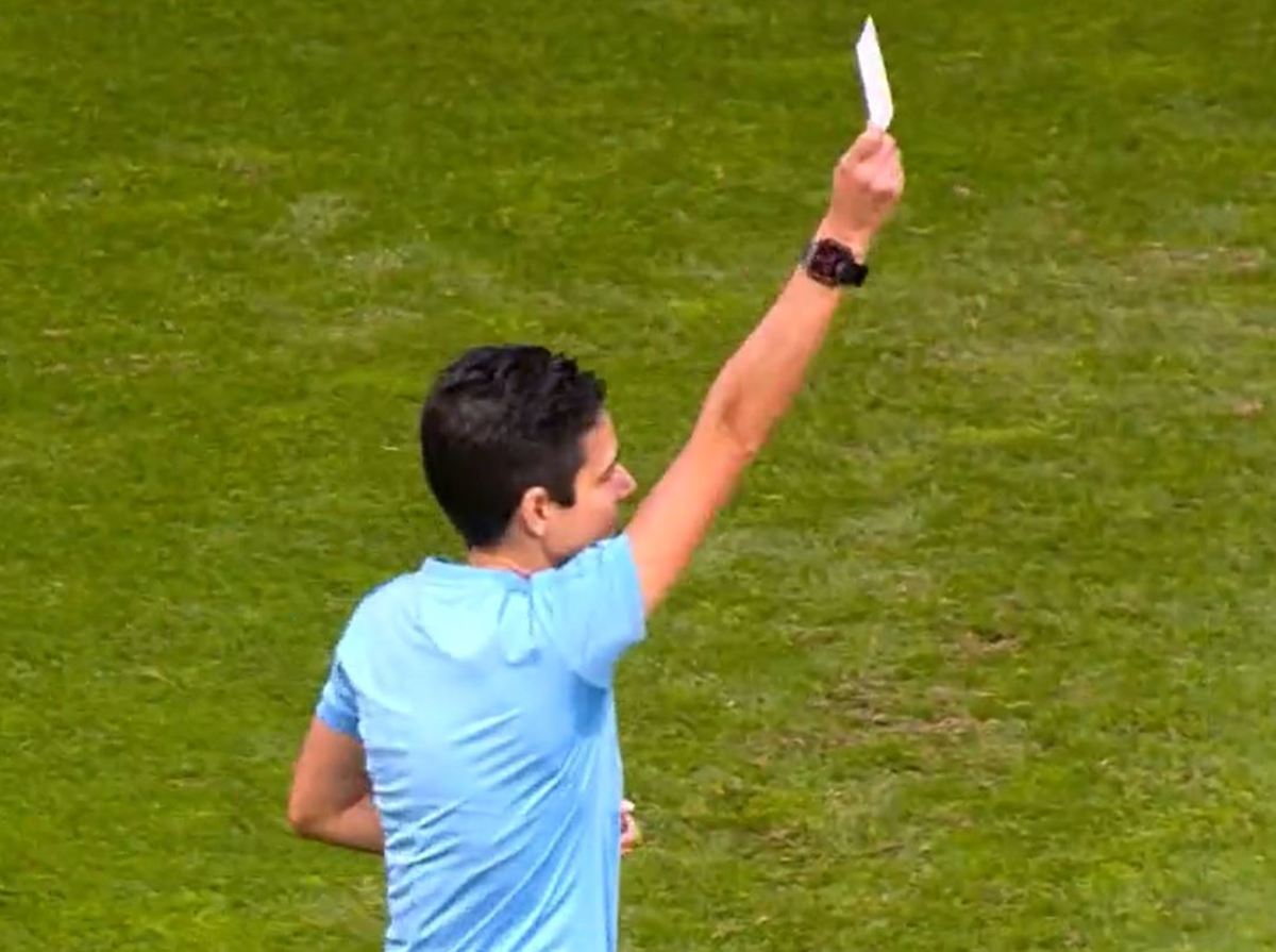 A referee pictured showing a white card during a Women's Cup game between Benfica and Sporting Lisbon in January 2023