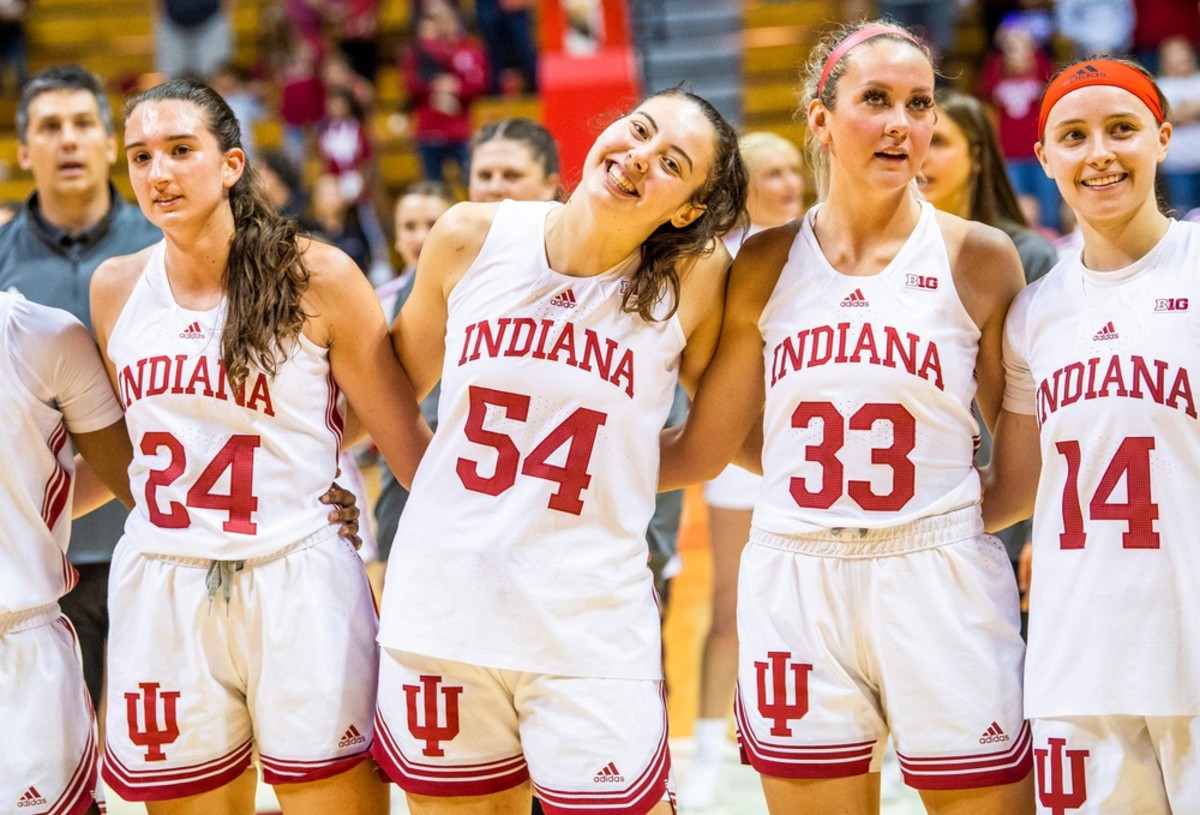 Indiana's Mackenzie Holmes (54) smiles with teammates Mona Zaric (24), Sydney Parrish (33) and Sara Scalia (14) as they sing the alma mater after the Indiana versus Kentucky Wesleyan women's basketball game at Simon Skjodt Assembly Hall on Friday, Nov. 4, 2022.