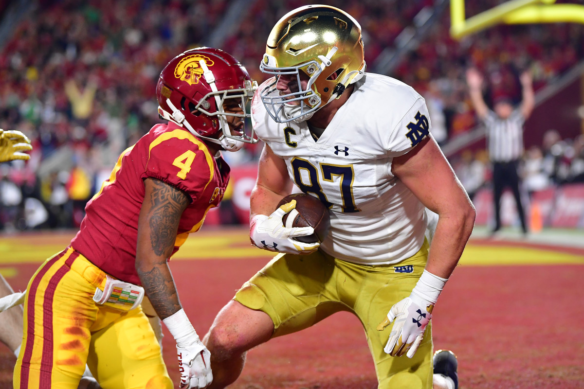 Los Angeles, California, USA; Notre Dame Fighting Irish tight end Michael Mayer (87) scores a touchdown against Southern California Trojans defensive back Max Williams (4) during the first half at the Los Angeles Memorial Coliseum.