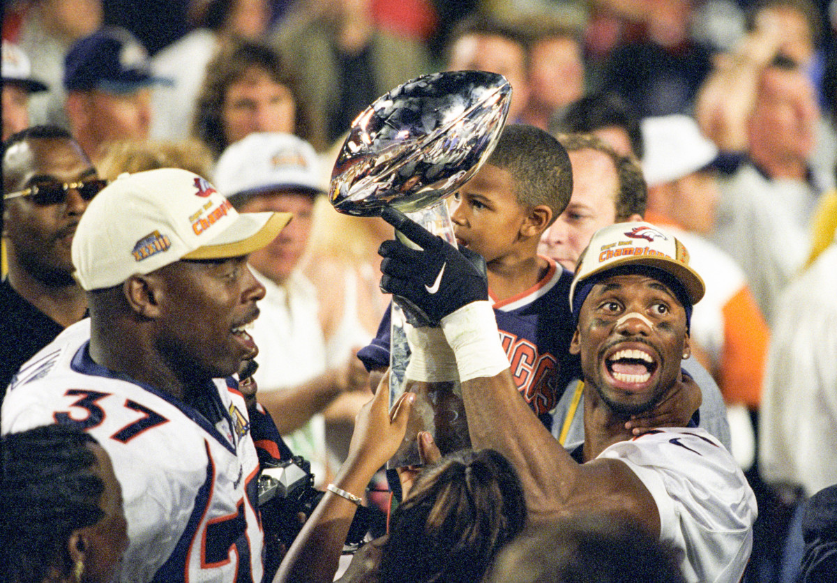 Football brought Crockett both joy (here, with his son, after Super Bowl XXXII) and pain.