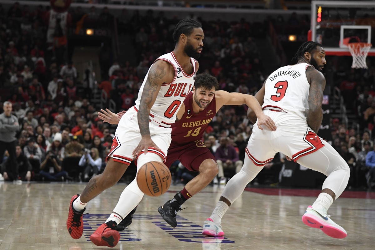 Chicago Bulls guard Coby White (0) moves the ball against Cleveland Cavaliers guard Raul Neto (19) as Chicago Bulls center Andre Drummond (3)