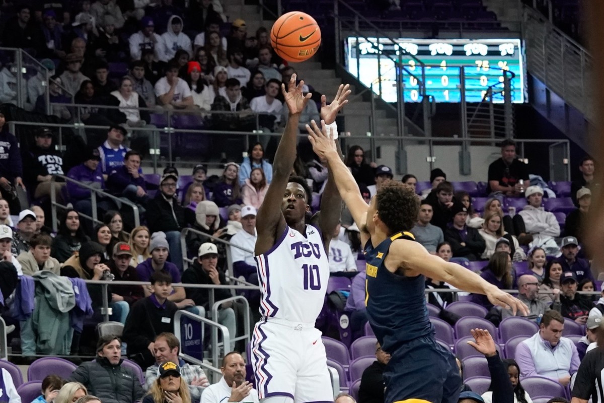 Jan 31, 2023; Fort Worth, Texas, USA; TCU Horned Frogs guard Damion Baugh (10) scores a three-point basket against West Virginia Mountaineers forward Tre Mitchell (3) during the first half at Ed and Rae Schollmaier Arena.