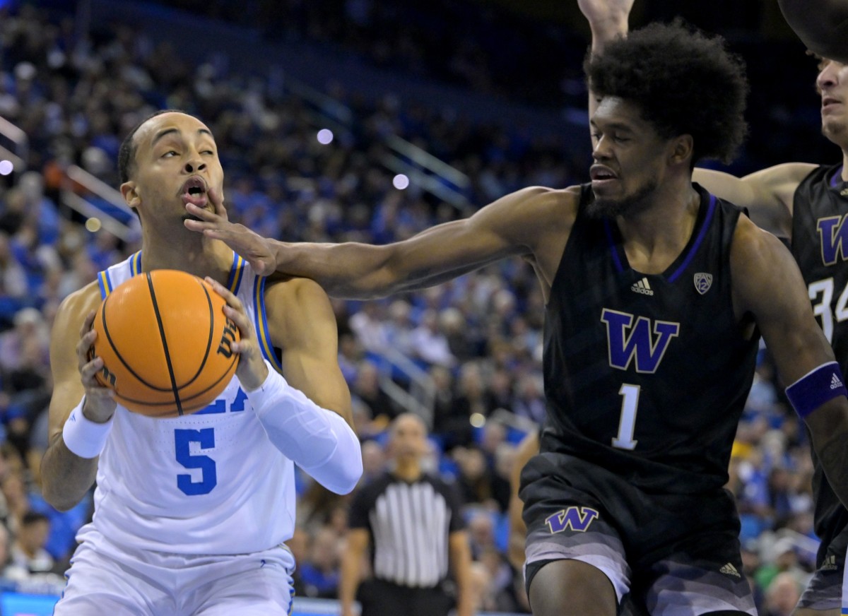 UCLA's Amari Bailey takes a hand to the face from the UW's Keion Brooks.