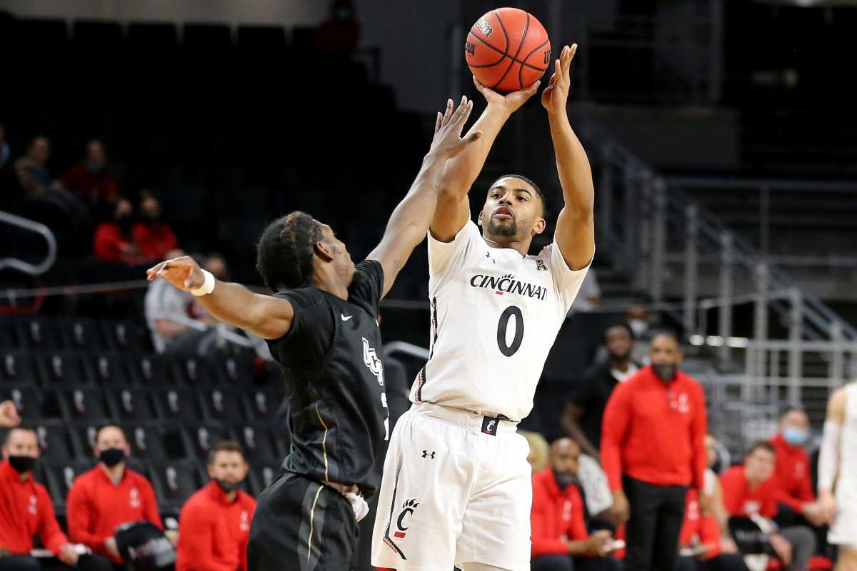 Cincinnati Bearcats guard David DeJulius (0) rises for a shot as UCF Knights guard Darius Perry (2) defends in the first half of an NCAA men's college basketball game, Sunday, Feb. 14, 2021, at Fifth Third Arena in Cincinnati. Ucf Knights At Cincinnati Bearcats Feb 14