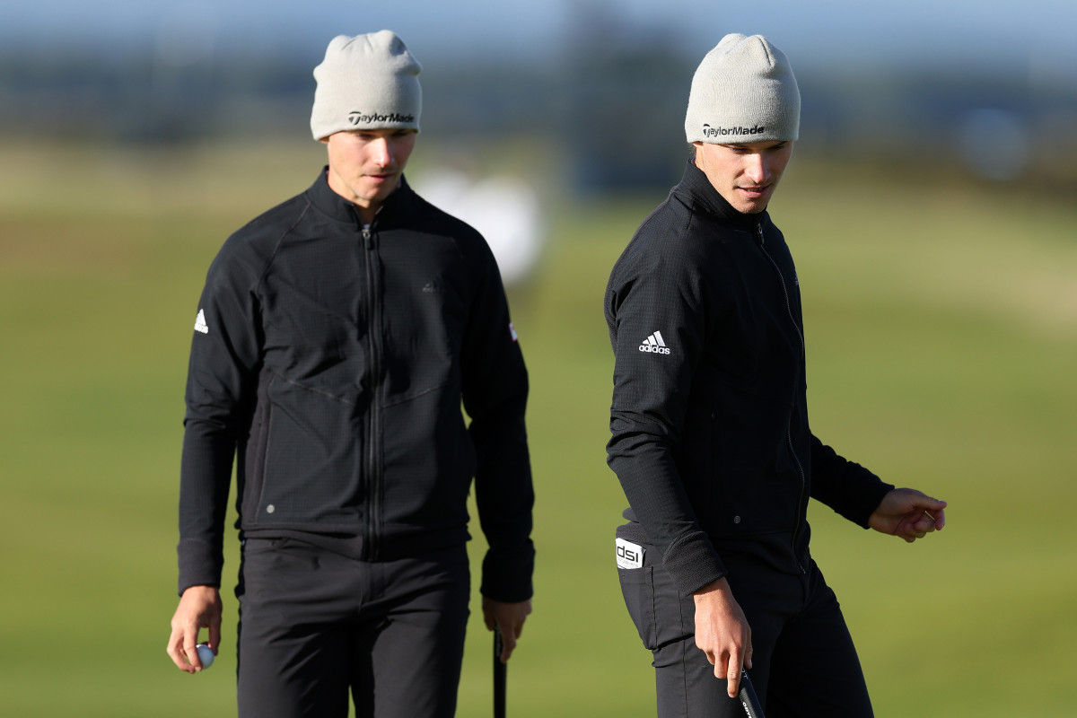 Nicolai Hojgaard of Denmark looks on as Rasmus Hojgaard of Denmark prepares to putt on the 16th green on Day Three of the Alfred Dunhill Links Championship.