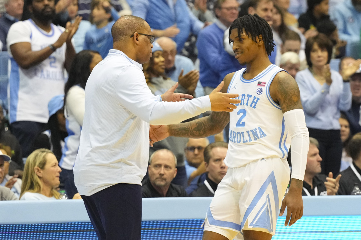 North Carolina Tar Heels coach Hubert Davis greets guard Caleb Love (2) after he come out of the game