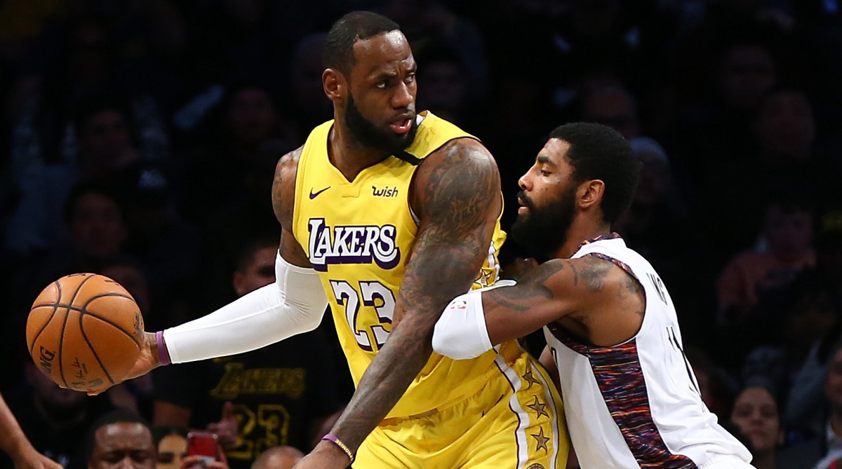 LeBron James of the Lakers is guarded by Kyrie Irving of the Nets