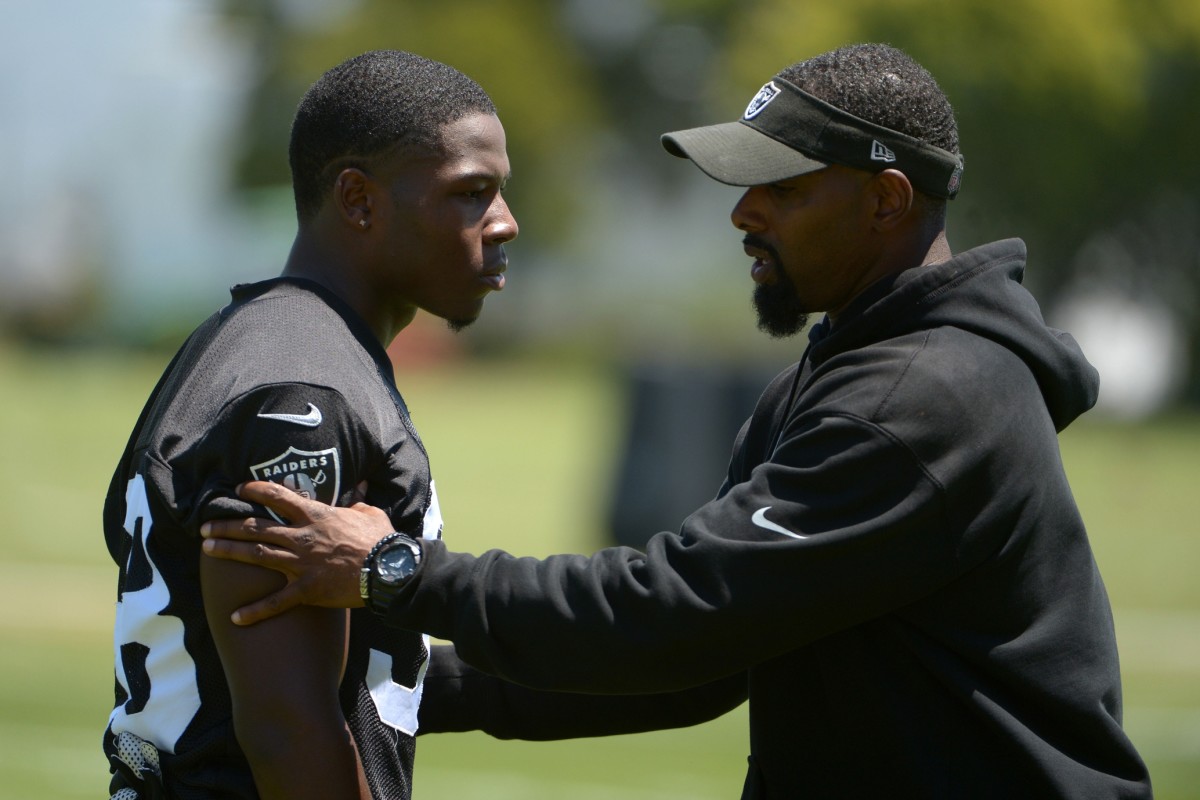 Jun 10, 2014; Oakland Raiders cornerback T.J. Carrie (38) and assistant defensive backs coach Marcus Robertson at organized team activities. Mandatory Credit: Kirby Lee-USA TODAY