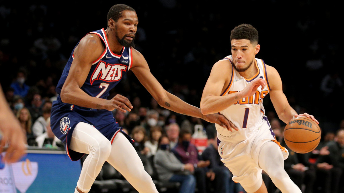 Kevin Durant guards Devin Booker during a Nets-Suns game