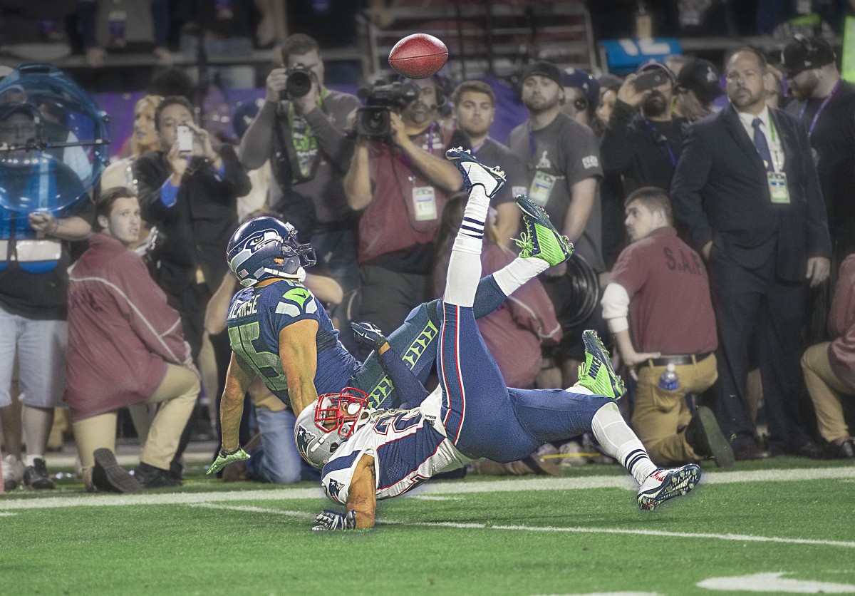 Jermaine Kearse falls alongside Malcolm Butler as he reaches for a catch in the fourth quarter of Super Bowl 49