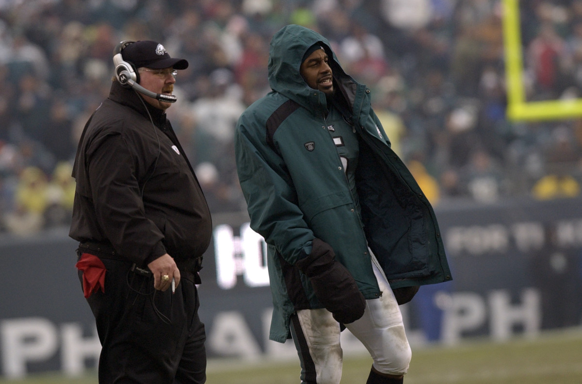 Philadelphia Eagles coach Andy Reid and quarterback Donovan McNabb stand on the sidelines, McNabb with his helmet off and a coat on