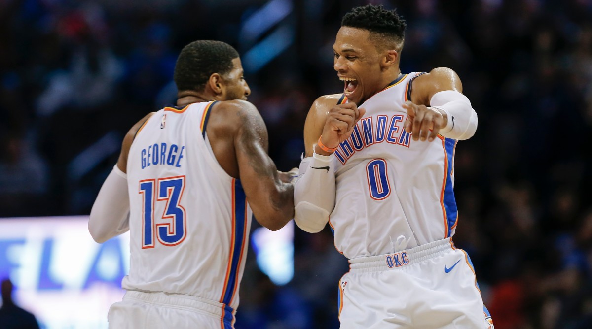 Thunder guard Russell Westbrook (0) and forward Paul George (13) celebrate after Westbrook hit a three-point basket during the second half of a game.
