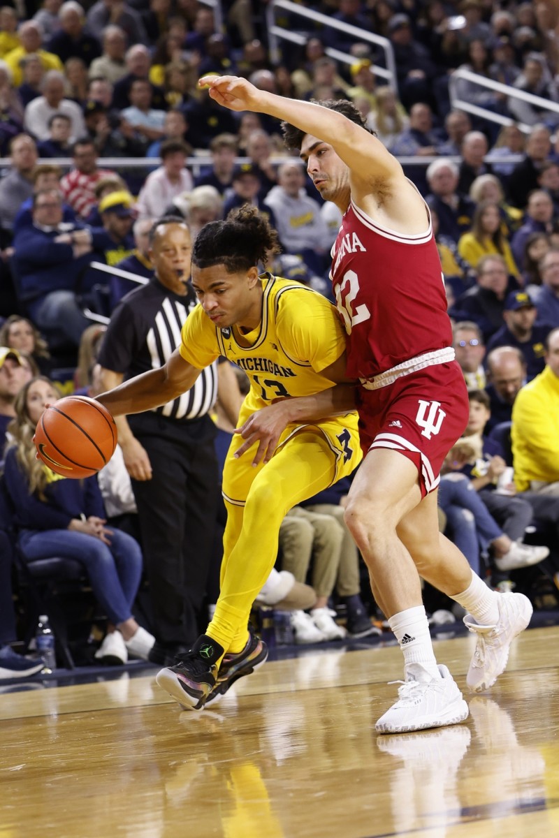 Jett Howard (13) dribbles the ball as Indiana Hoosiers guard Trey Galloway (32) defends in the first half at Crisler Center.
