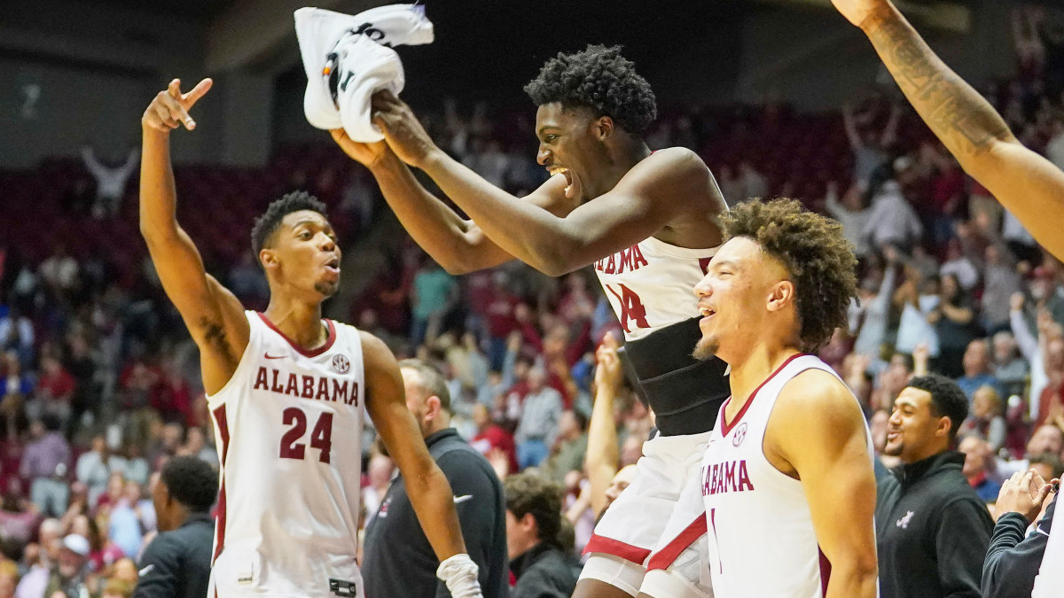 Alabama players leap in celebration on the bench
